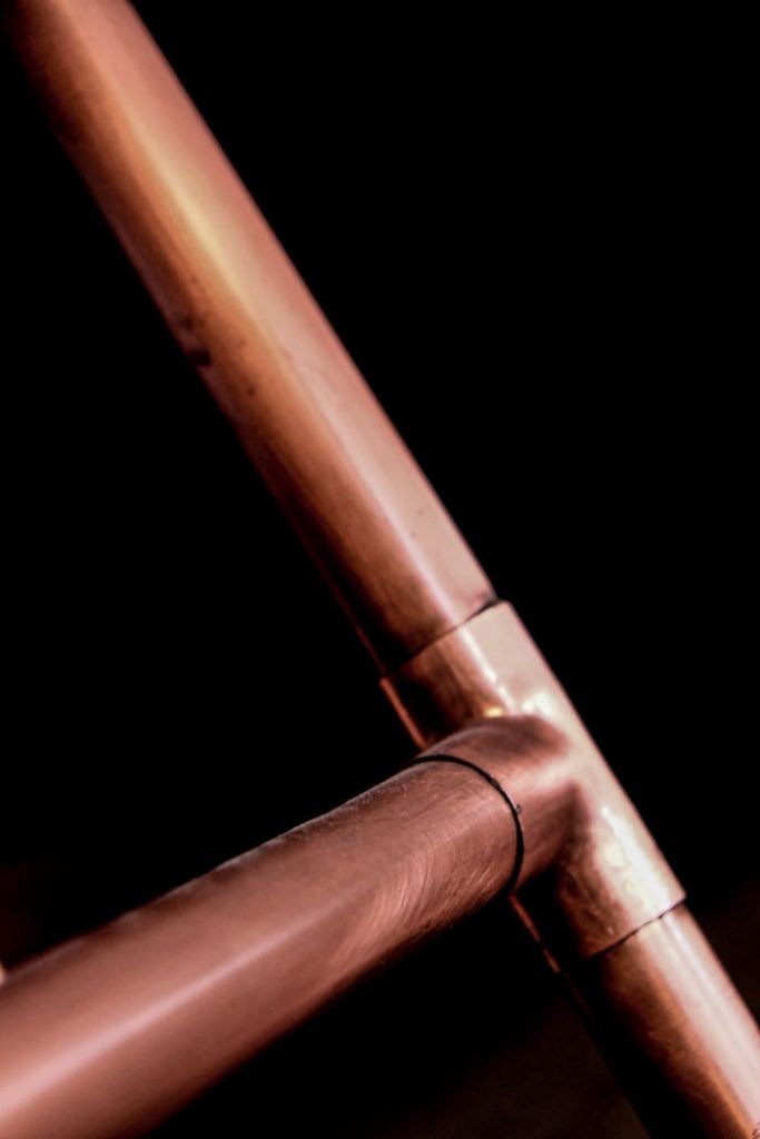 copper-pipes-on-black-background-3721272 Industrial copper pipes close-up with a dark background, highlighting metallic textures.